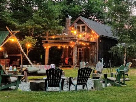Chairs surrounding fire pit outside with warm, hanging lights